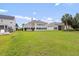 View of a large backyard showcasing lawn and the rear exterior of neighboring homes at 2210 Haystack Way, Myrtle Beach, SC 29579