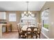 Bright dining room featuring a chandelier, natural light from surrounding windows, and stylish chairs with striped cushions at 2210 Haystack Way, Myrtle Beach, SC 29579