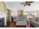Spacious living room featuring a fireplace, ceiling fan, and hardwood floors that connect to the kitchen and dining area at 2210 Haystack Way, Myrtle Beach, SC 29579