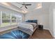 Cozy bedroom features a tray ceiling, ceiling fan, natural light, and hardwood flooring at 2212 Leeboard Ct., Myrtle Beach, SC 29579