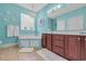 Bright blue bathroom featuring a tub, glass block window, and dark wood vanity with white countertops at 2369 Clandon Dr., Myrtle Beach, SC 29579