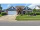 Charming home featuring a well manicured lawn, flowering tree, brick accents, and an attached garage at 2369 Clandon Dr., Myrtle Beach, SC 29579