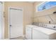 Bright laundry room featuring a washer and dryer, shelving, and a window for natural light at 2510 Oriole Dr., Murrells Inlet, SC 29576