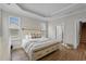 Serene bedroom featuring a tray ceiling, wood flooring, and a view of the staircase and bathroom at 264 Switchgrass Loop, Little River, SC 29566