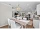 Elegant dining area showing a wooden table with seating, modern lighting, and seamless flow into the kitchen at 264 Switchgrass Loop, Little River, SC 29566