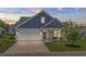 Charming home with blue and tan siding, a well-manicured lawn, and a blossoming tree, perfect for curb appeal at 264 Switchgrass Loop, Little River, SC 29566