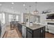 Spacious kitchen island with stainless steel appliances, an eat-in area, modern pendant lighting, and wood flooring at 264 Switchgrass Loop, Little River, SC 29566