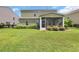 Lush backyard with a well-maintained lawn, green exterior, and a screened porch at 2685 Scarecrow Way, Myrtle Beach, SC 29579