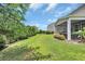 Large, well-manicured backyard with green grass, privacy hedges, and a screened porch off the home at 2685 Scarecrow Way, Myrtle Beach, SC 29579