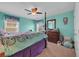 Vibrant bedroom with turquoise walls, a ceiling fan, and colorful bedding at 2685 Scarecrow Way, Myrtle Beach, SC 29579