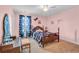 Bright bedroom with pink walls, a wooden bed frame, and a ceiling fan fixture at 2685 Scarecrow Way, Myrtle Beach, SC 29579