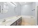 Well-lit bathroom with dual sinks, a soaking tub, neutral tile flooring, and modern fixtures at 307 Russ Rd., Loris, SC 29569