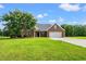 Charming brick home with a two-car garage, manicured lawn, and mature landscaping at 307 Russ Rd., Loris, SC 29569