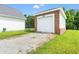 Exterior view of detached garage, brick exterior, white door, paved drive way, and green lawn at 307 Russ Rd., Loris, SC 29569