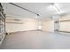 Spacious garage with overhead lighting, shelving, door to the yard, and finished concrete floors at 307 Russ Rd., Loris, SC 29569