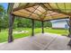 View of the gazebo in the back yard with string lights, curtains, fire pit and privacy fence at 307 Russ Rd., Loris, SC 29569