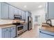 Updated kitchen with stainless steel appliances, blue cabinets, and luxury vinyl plank flooring at 307 Russ Rd., Loris, SC 29569