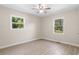 Well-lit bedroom with two windows overlooking a green lawn, ceiling fan, and light wood floors at 3269 Sims Rd., Marion, SC 29571