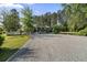 Wide gravel driveway leads to a well-maintained home with lush, mature trees at 3269 Sims Rd., Marion, SC 29571