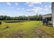 Expansive backyard featuring lush green grass, a picturesque pond, and a covered patio at 417 Spruce Pine Way, Conway, SC 29526