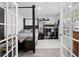Bedroom through double doors with a dark wood four poster bed, shelves, and a view to the outside at 417 Spruce Pine Way, Conway, SC 29526