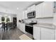 Well-lit kitchen featuring white cabinets, stainless steel appliances and a dining area at 417 Spruce Pine Way, Conway, SC 29526