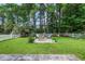 This backyard offers a charming fire pit area surrounded by lush landscaping and a classic white picket fence at 4536 Fringetree Dr., Murrells Inlet, SC 29576