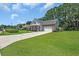 Well-maintained home showcasing lush green lawns, mature trees, and a concrete driveway at 4536 Fringetree Dr., Murrells Inlet, SC 29576