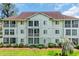 Multi-story condo building with multiple windows and outdoor balconies surrounded by beautiful green landscaping at 4650 Greenbriar Dr. # A5, Little River, SC 29566