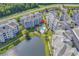 An aerial view of a condo complex showcasing a pool, a pond and the surrounding lush landscape and parking at 4821 Luster Leaf Circle # 202, Myrtle Beach, SC 29577