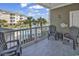A charming condo balcony with gray chairs, beach themed decor, and views of the community pool and landscaping at 4821 Luster Leaf Circle # 202, Myrtle Beach, SC 29577