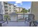 A condo balcony with gray chairs overlooking a pool and manicured landscaping, perfect for relaxation at 4821 Luster Leaf Circle # 202, Myrtle Beach, SC 29577