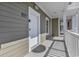 A white front door with a round welcome mat greets you on a cozy, sheltered porch area at 4821 Luster Leaf Circle # 202, Myrtle Beach, SC 29577