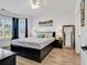 Bright main bedroom features a large window with blue curtains, a bed with storage, and wood floors at 4821 Luster Leaf Circle # 202, Myrtle Beach, SC 29577