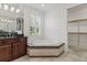 Bright bathroom featuring jacuzzi bathtub, granite counters, and shuttered windows at 496 Starlit Way, Myrtle Beach, SC 29579