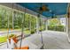 Inviting screened porch features a swing, fan, and view of the fenced backyard at 496 Starlit Way, Myrtle Beach, SC 29579