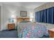 Bright bedroom featuring cozy decor, a colorful bedspread, and ambient lighting at 523 S Ocean Blvd. # 305, North Myrtle Beach, SC 29582