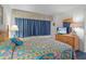 This bedroom offers a bed with colorful bedding and views from the window at 523 S Ocean Blvd. # 305, North Myrtle Beach, SC 29582