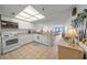View of the open kitchen with white appliances, tile floors, and a view to the living room at 523 S Ocean Blvd. # 305, North Myrtle Beach, SC 29582
