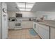 Bright kitchen features white cabinetry, appliances, and tile flooring for a clean, modern aesthetic at 523 S Ocean Blvd. # 305, North Myrtle Beach, SC 29582