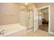 Bathroom features an enclosed glass shower, soaking tub and neutral tile flooring at 5650 Barefoot Resort Bridge Rd. # 431, North Myrtle Beach, SC 29582