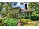 The home's rear exterior features multiple windows, verdant landscaping, and a brick pathway at 571 Fernwood Rd., Murrells Inlet, SC 29576