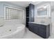 Bright bathroom with glass block window, soaking tub, storage cabinet and granite countertop at 571 Fernwood Rd., Murrells Inlet, SC 29576