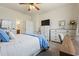 Cozy bedroom showcases neutral decor with a comfortable bed, a TV, a desk and an ensuite bath through an open door at 5716 Lombardia Circle, Myrtle Beach, SC 29579