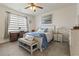 Bright bedroom features a ceiling fan, neutral decor, an adjacent desk, and a decorative bench at the foot of the bed at 5716 Lombardia Circle, Myrtle Beach, SC 29579