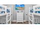 Bright bedroom featuring white bunk beds, dresser, and a TV displaying a vibrant beach scene at 6001 - 1195 S Kings Hwy., Myrtle Beach, SC 29575