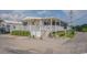Beautiful beach house featuring a spacious front porch with white railings and a well-manicured garden at 6001 - 1459 S Kings Hwy., Myrtle Beach, SC 29575