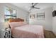 Cozy bedroom with light walls, ceiling fan, and a large window providing natural light at 6001 - Z-49 S Kings Hwy., Myrtle Beach, SC 29575