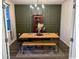 Stylish dining room featuring an olive green accent wall, rustic wood table, and modern chandelier at 651 Choctaw Dr., Conway, SC 29526