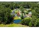 Aerial view of a neighborhood showcasing well-maintained homes, mature trees, and a serene pond at 6576 Pebble Beach Crescent, Myrtle Beach, SC 29588